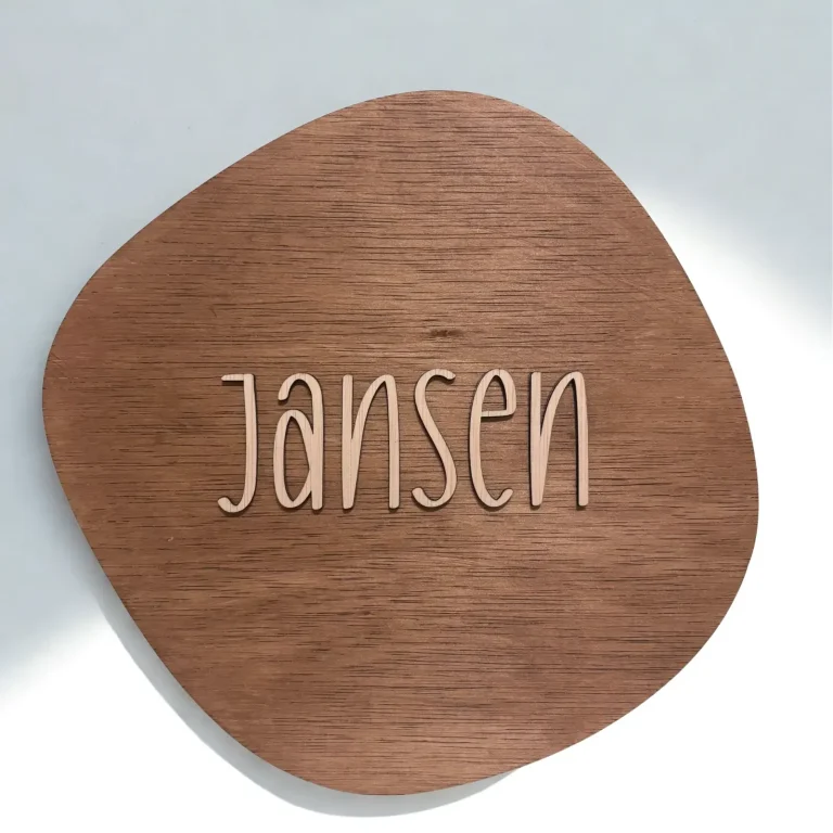 Houten naambord in een donkere kleur net een familie naam erop